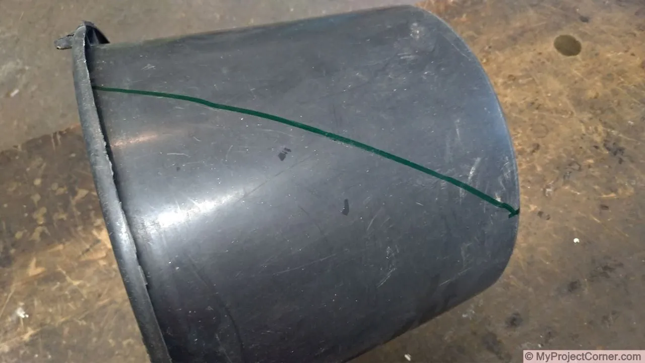 Marking out sides of plastic bucket used for chicken slaughter cone