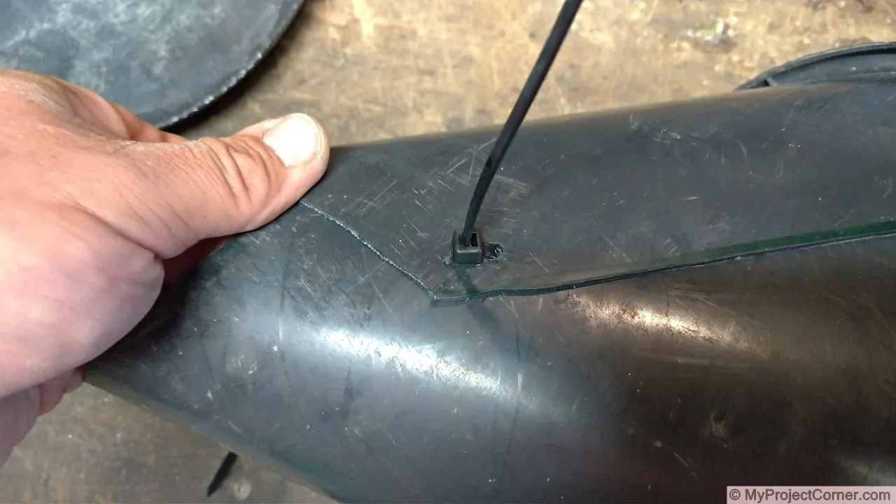 Inserting cable tie to attach chicken cone